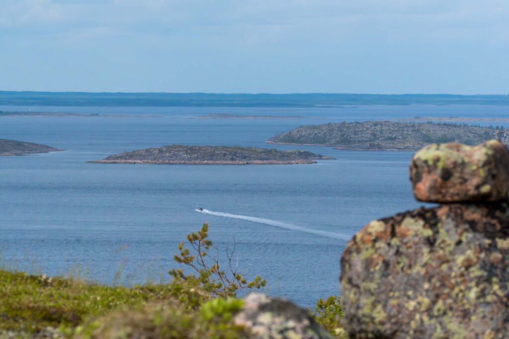 Вид на острова архипелага Кузова с высоты, море и след от катера на фоне северного горизонта, фото к туру Магия Соловецких островов