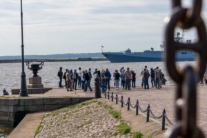 Люди у воды в Кронштадте на морской набережной у кораблей